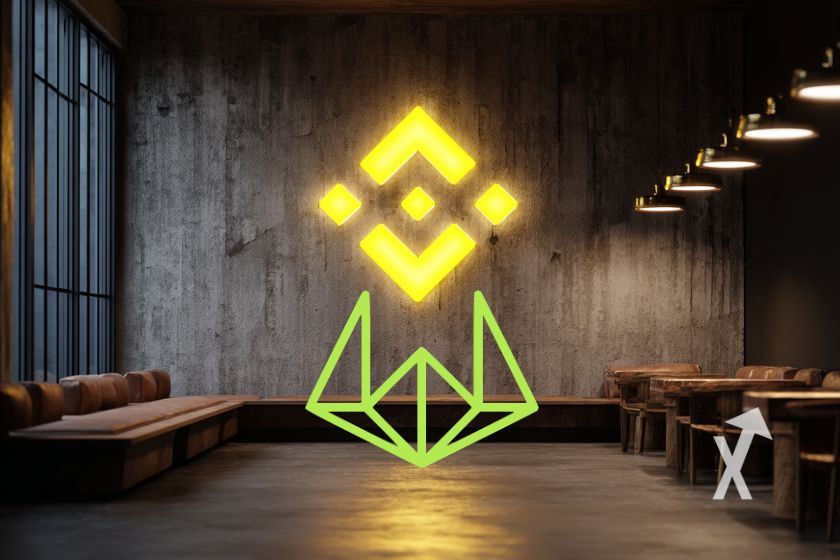 Logo Wintermute en vert en logo Binance en jaune néon sur un mur d'une salle d'attente d'un immeuble avec canapés