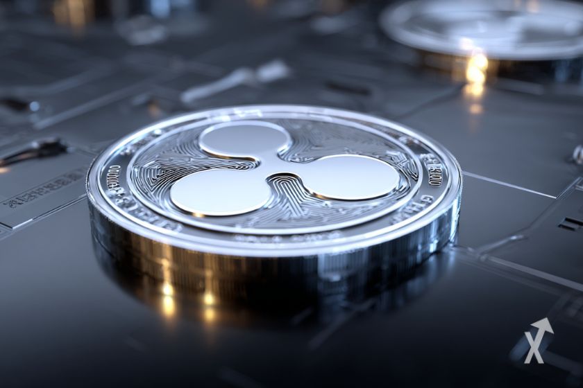 Une pièce argentée de Ripple (XRP) sur un sol gris